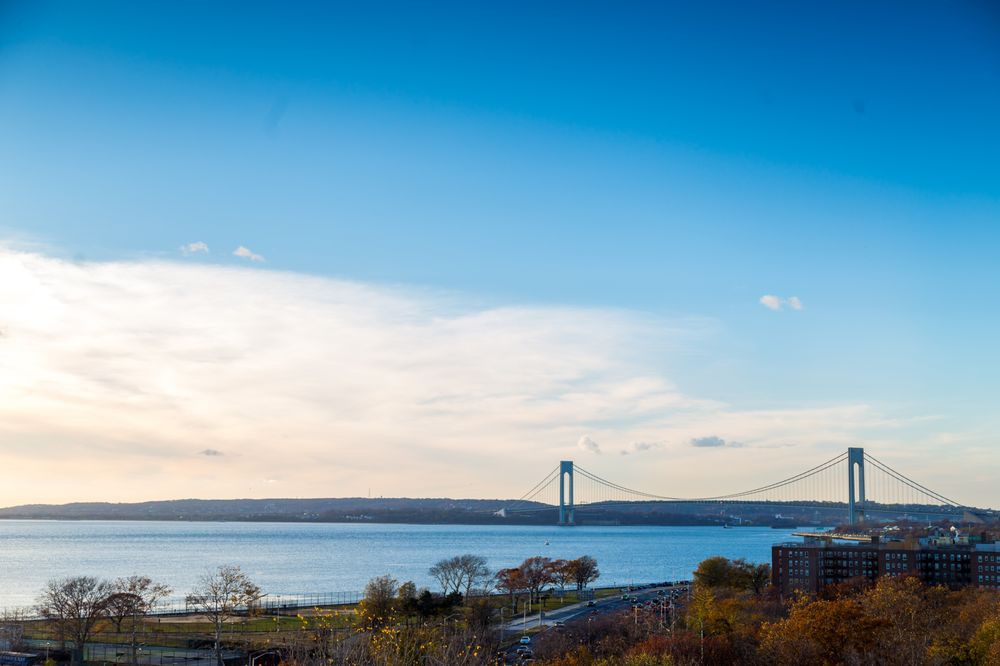 A scenic view of a bridge spanning across a body of water under a clear blue sky.