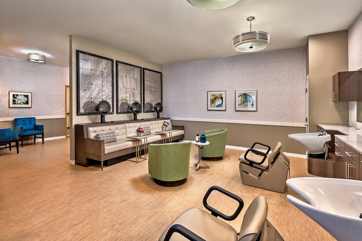 A modern salon interior featuring comfortable seating, hair dryers, and stylish decor.