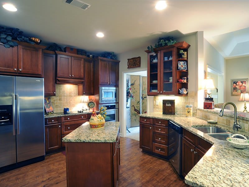 A modern kitchen with wood cabinets and granite countertops.