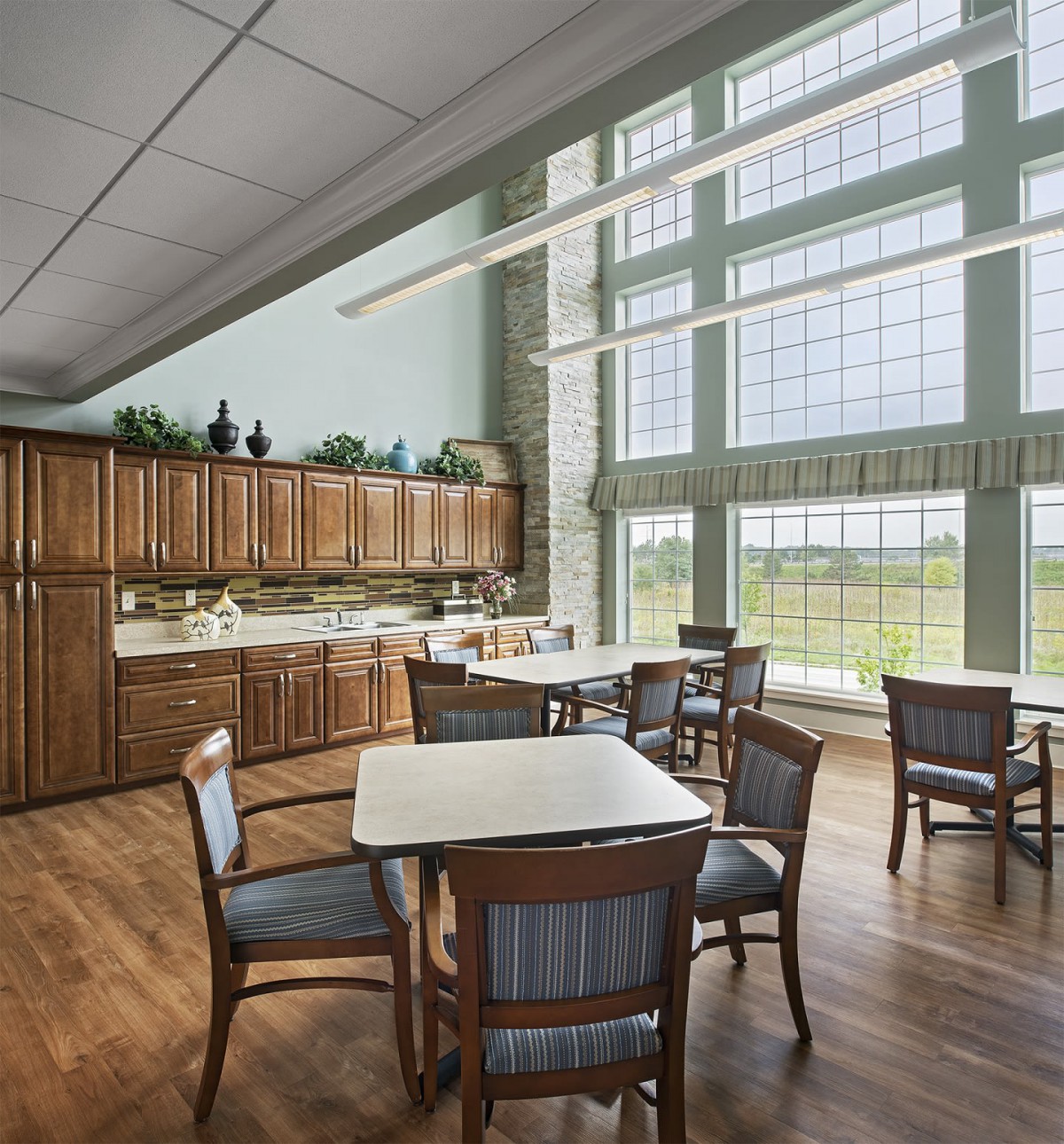 A bright dining area with wooden furniture and large windows.