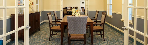 A cozy dining area featuring a wooden table and comfortable chairs, adorned with floral decorations.