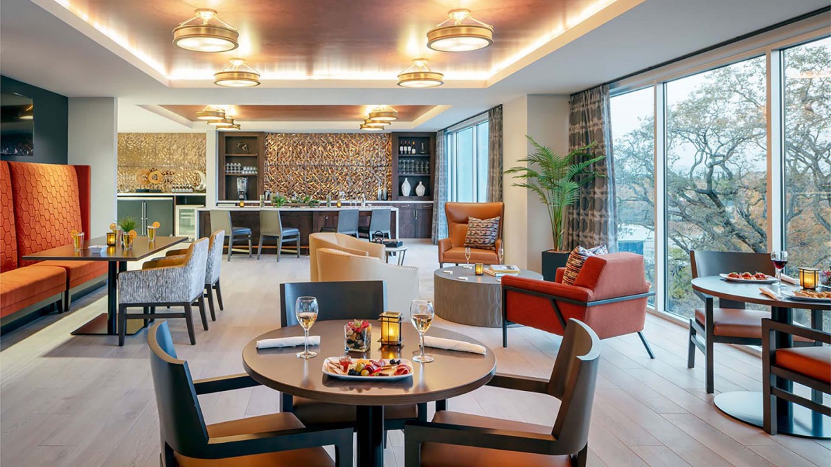 A modern lounge featuring a cozy seating area with a bar and stylish decor.