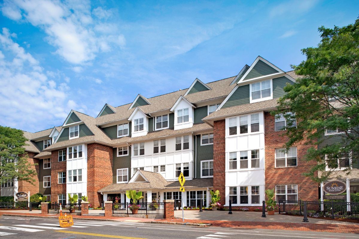 A modern residential apartment building with a mix of brick and siding exterior.