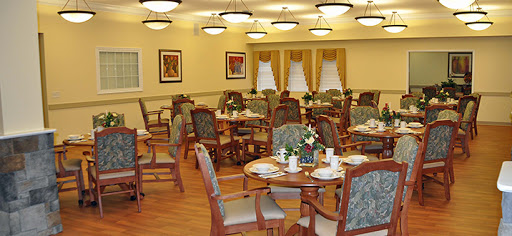 A spacious dining area featuring neatly arranged tables and chairs, adorned with floral centerpieces.