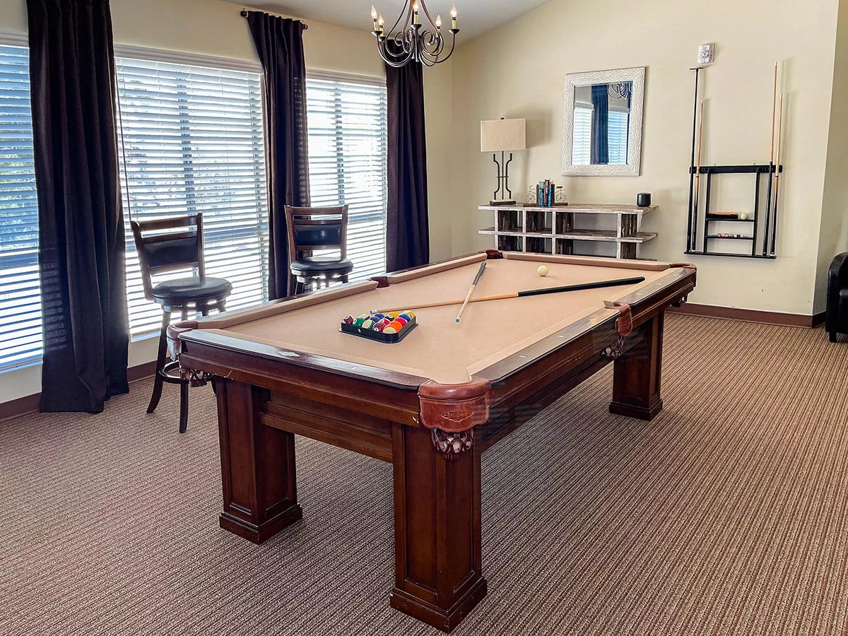 A stylish pool room featuring a billiard table and elegant furnishings.