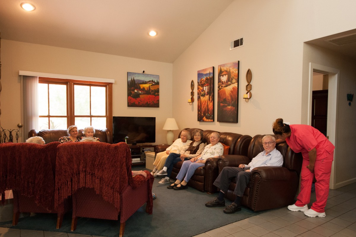 A group of people relaxing in a living room with comfortable seating and wall art.