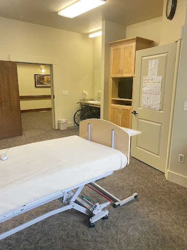 A view of a hospital room featuring an adjustable bed and medical furniture.