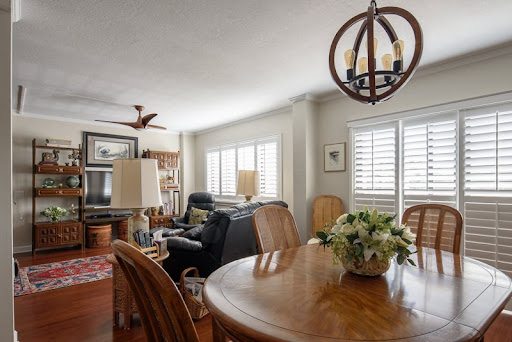 A cozy living room and dining area featuring a wooden table, comfortable seating, and stylish lighting.