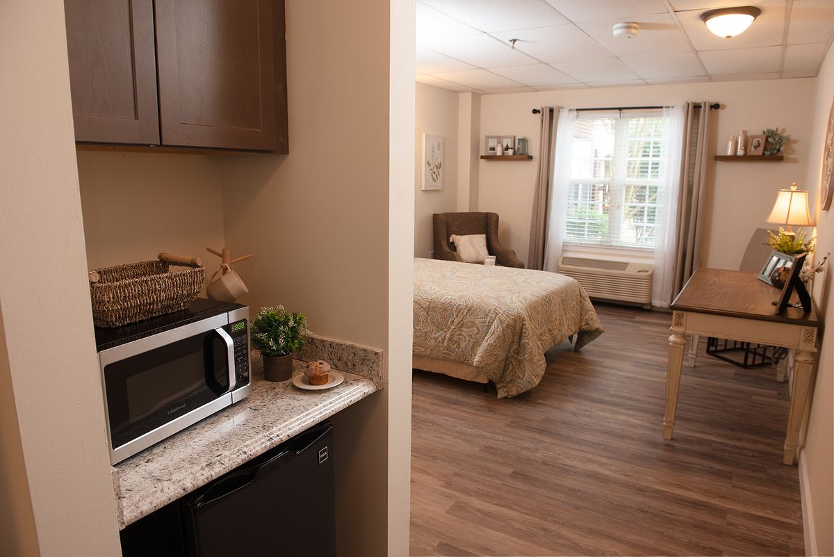 A cozy, modern bedroom with natural light and a kitchenette.