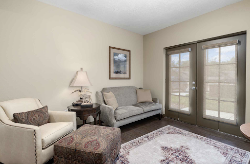 A cozy living room featuring a comfortable sofa, armchair, and natural light from the windows.