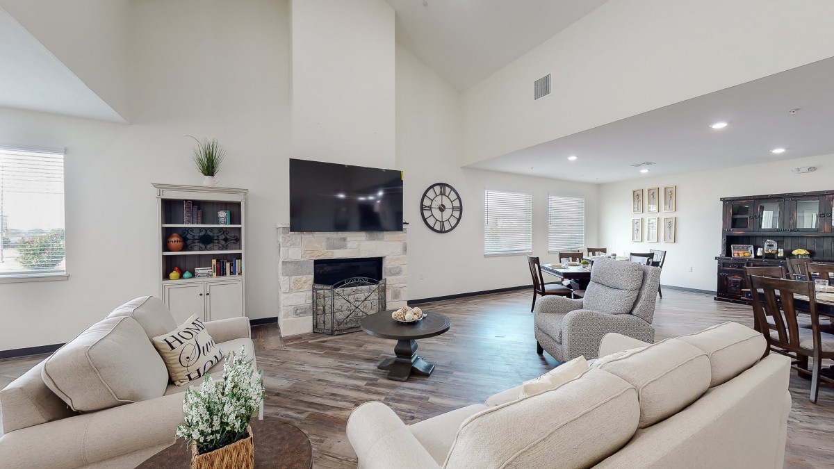 A modern living room with a fireplace, large television, and comfortable seating.