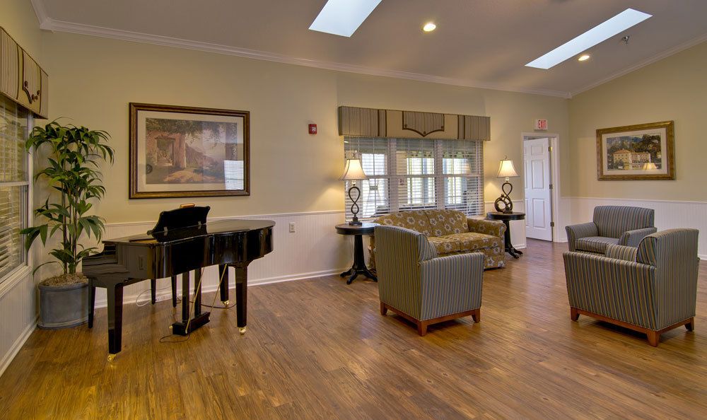 A cozy living room with a grand piano, comfortable seating, and elegant decor.