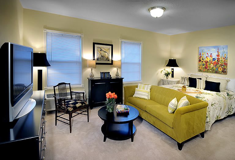 A cozy living room featuring a bright yellow sofa and elegant decor.