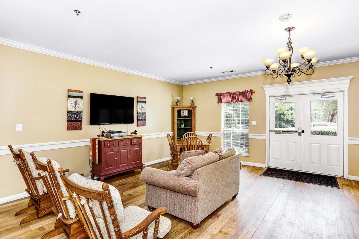 Cozy living room featuring a sofa, rocking chairs, and a television.