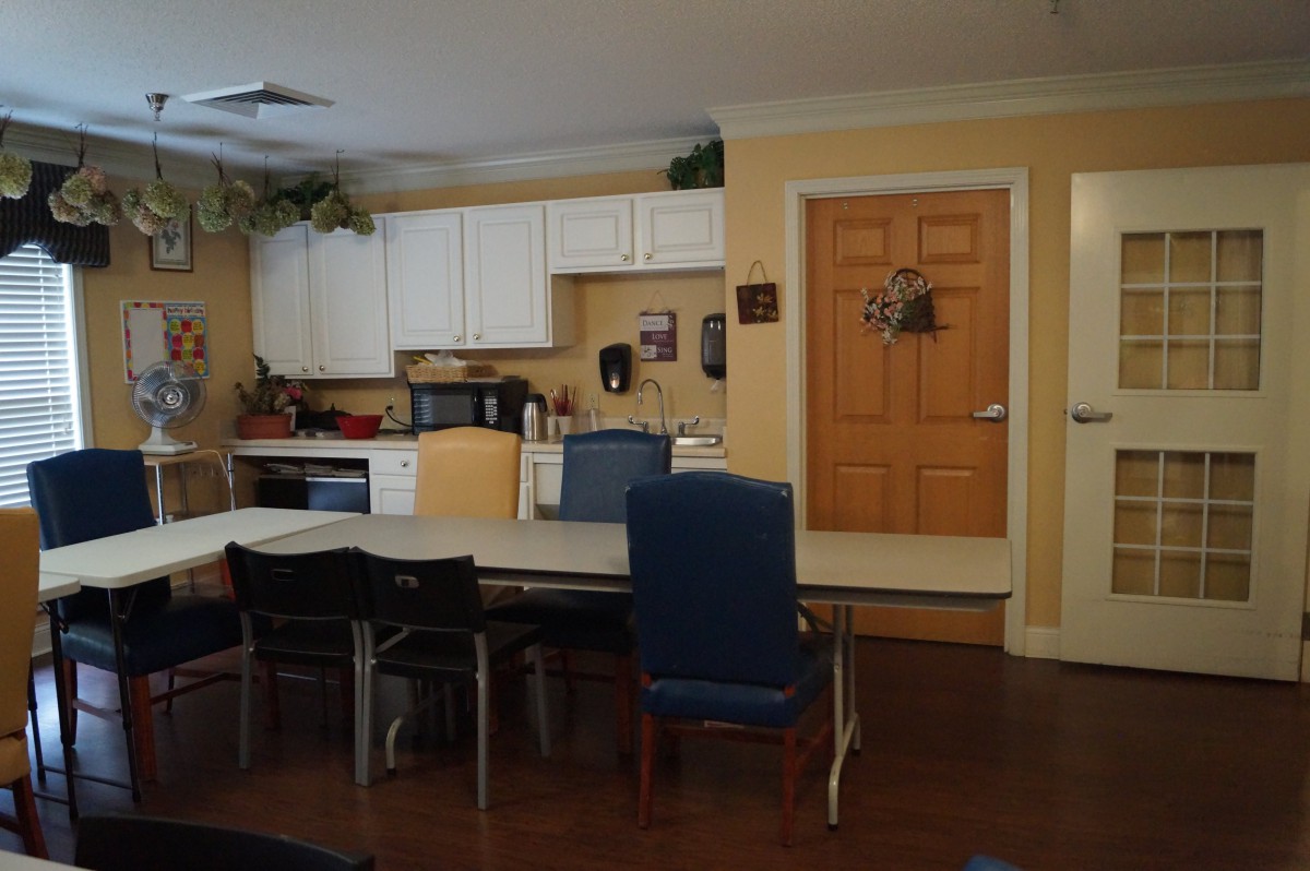 A cozy kitchen interior with a dining table and chairs, surrounded by cabinets and appliances.