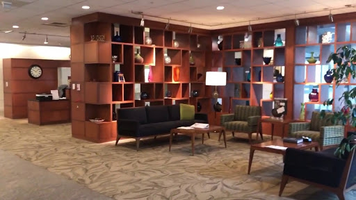 A modern lobby seating area featuring stylish furniture and unique shelving.