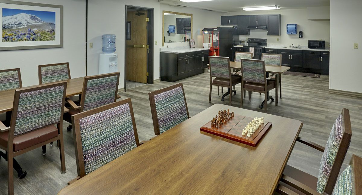 A modern meeting room with a chessboard on the table and chairs arranged around it.
