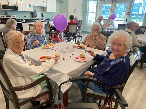 Residents enjoying a meal together at a community gathering, filled with laughter and celebration.