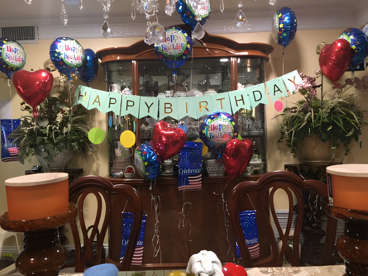 A festive birthday celebration setup with colorful balloons and a 'Happy Birthday' banner.