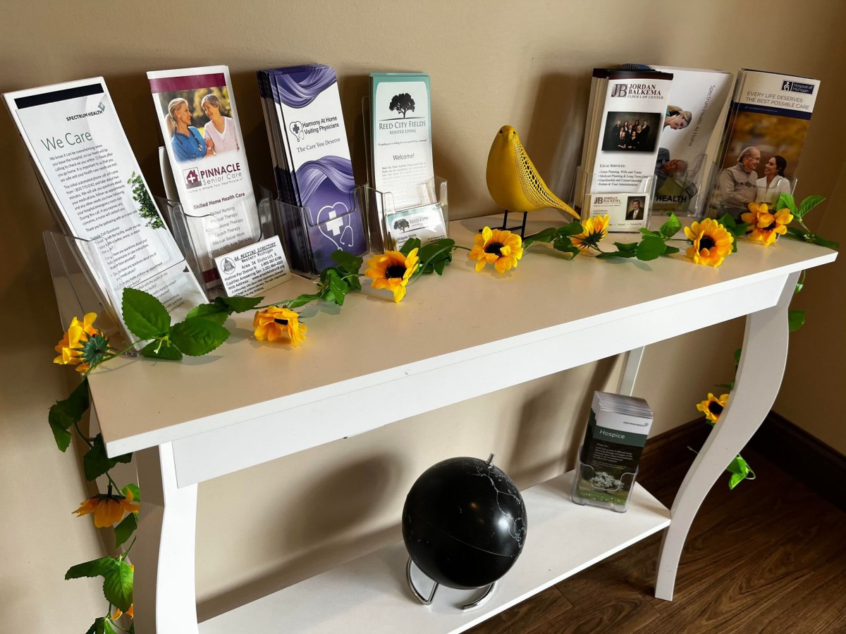 A neatly arranged table with brochures, decorative flowers, and a small globe.