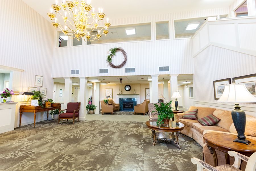 A spacious lobby with elegant decor, featuring a chandelier and comfortable seating.