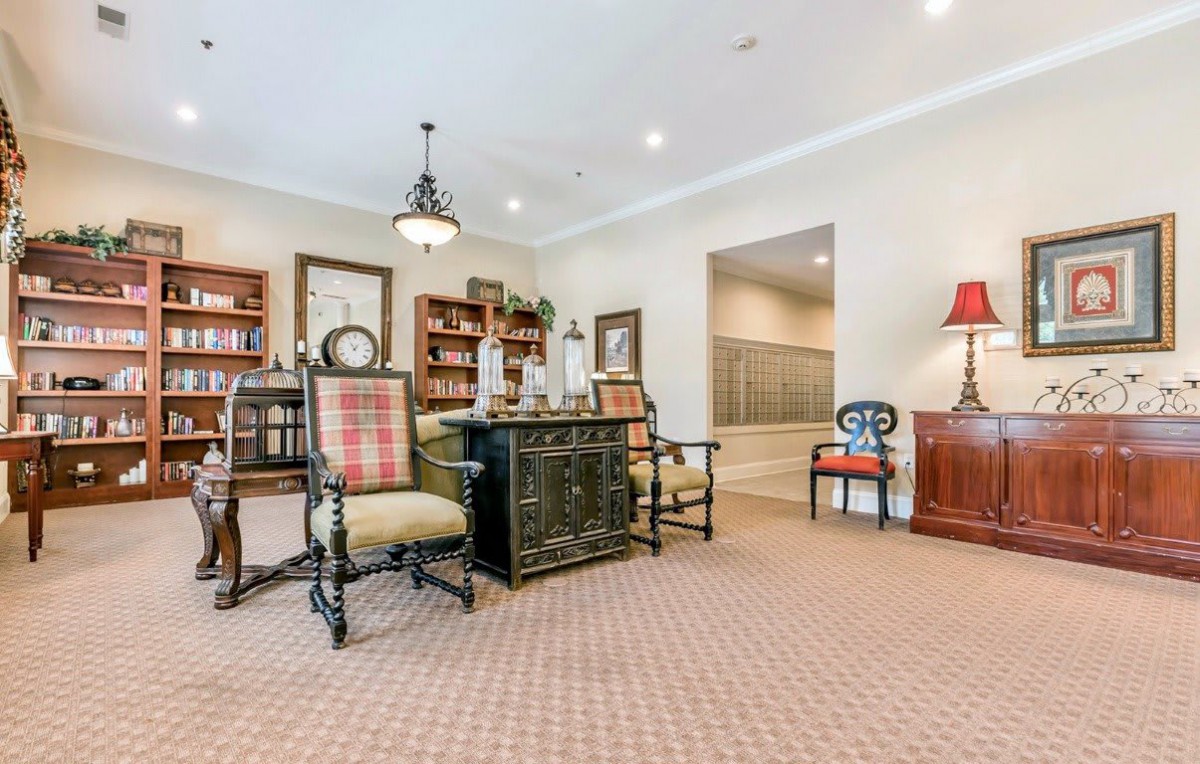A traditional office setting with a desk, chairs, and bookshelves.