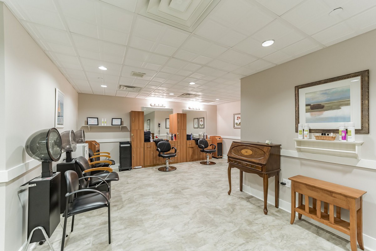 A modern hair salon interior with chairs and mirrors arranged neatly.