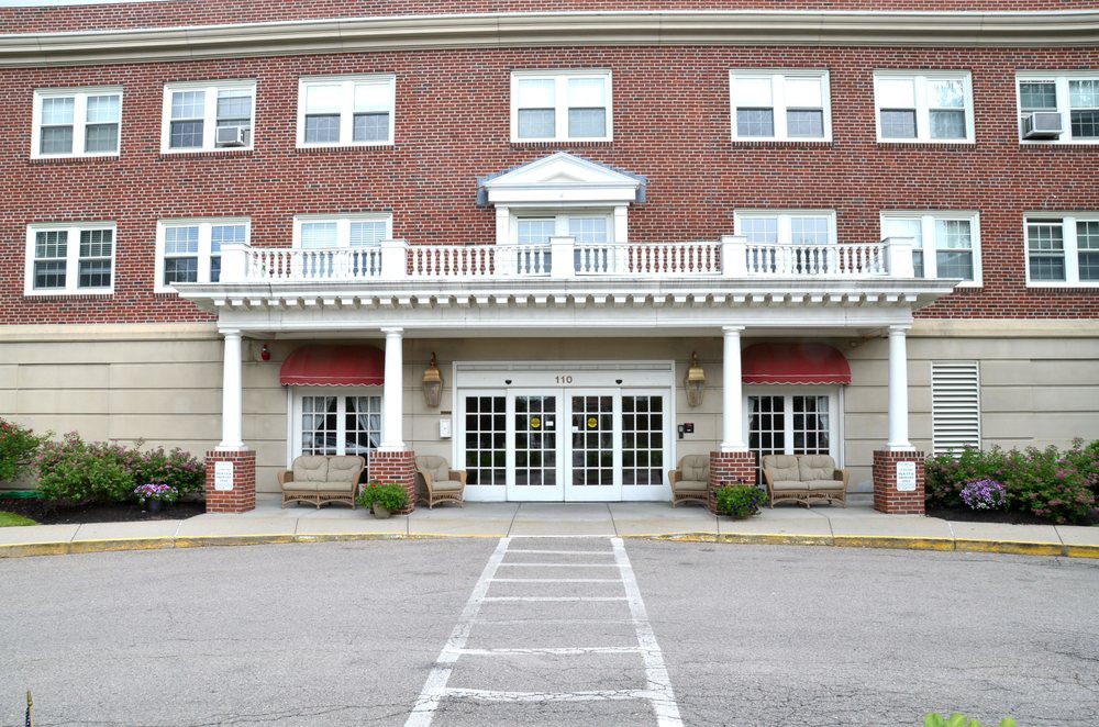 A brick facade hotel entrance with white columns and large glass doors.