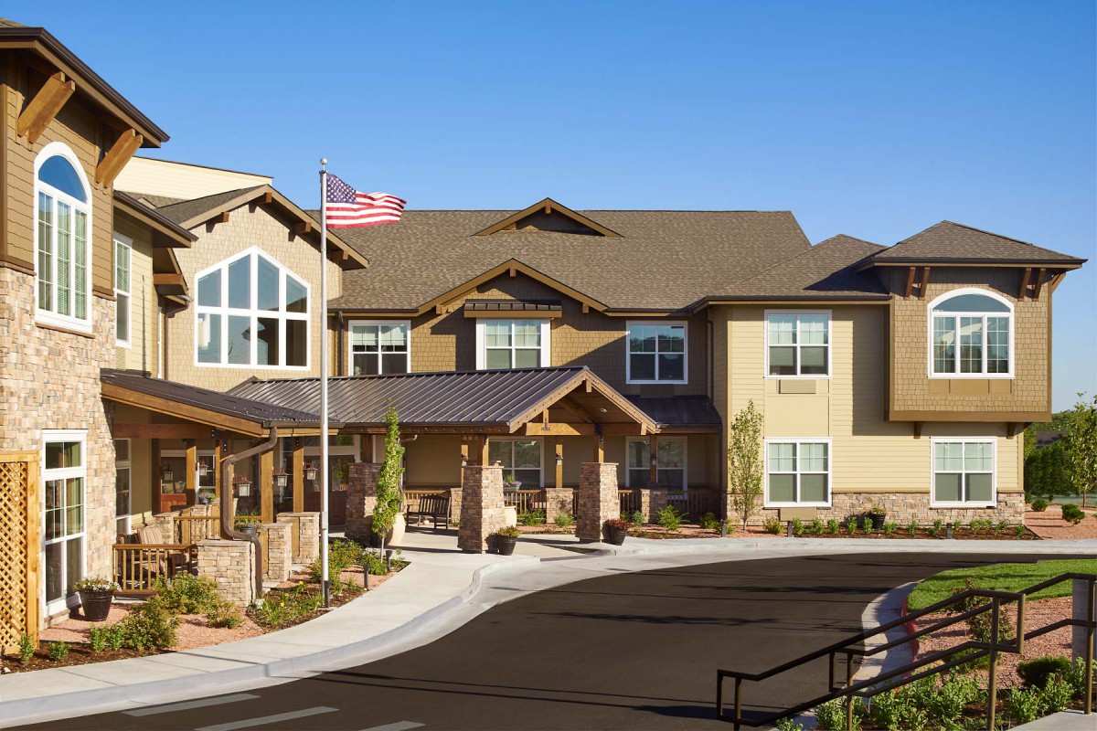 A two-story modern residential building with a welcoming entrance and well-kept landscaping on a sunny day.