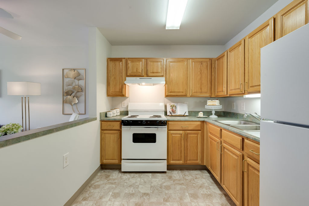 A clean and organized kitchen with wooden cabinets and a white stove.