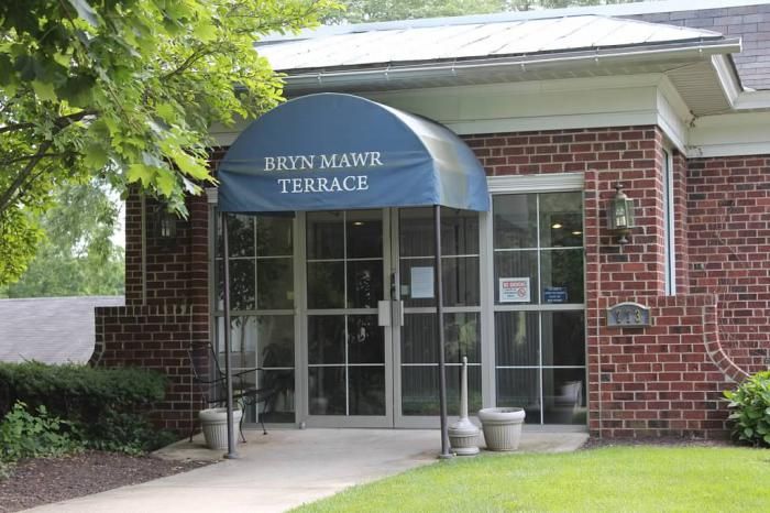 Entrance to a building with a blue awning labeled 'Bryn Mawr Terrace'.