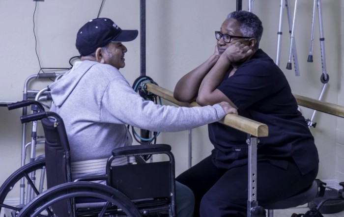 Two individuals engage in a supportive conversation during a therapy session.