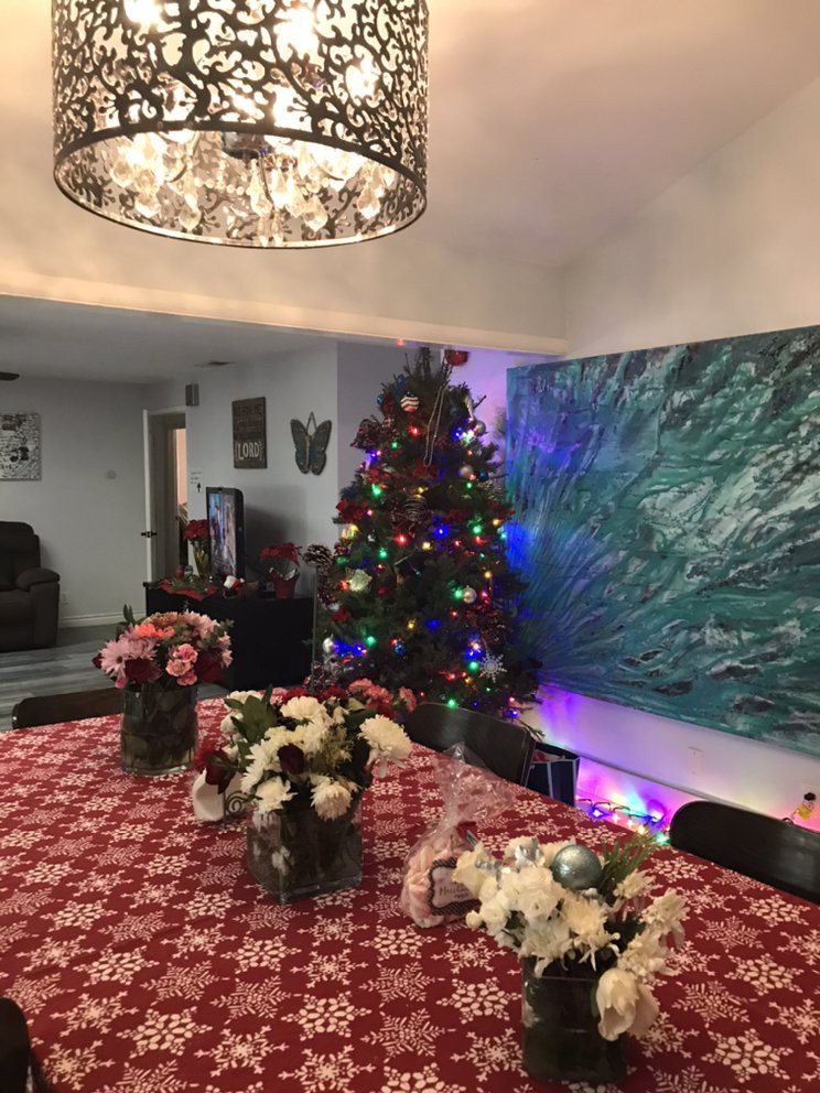 A warmly decorated dining room with a Christmas tree and a festive table setting.