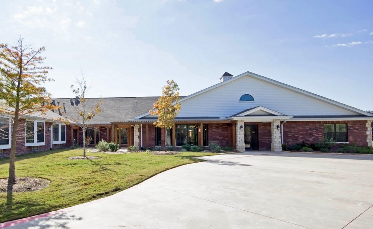 A suburban residential house with a spacious driveway and well-maintained lawn.