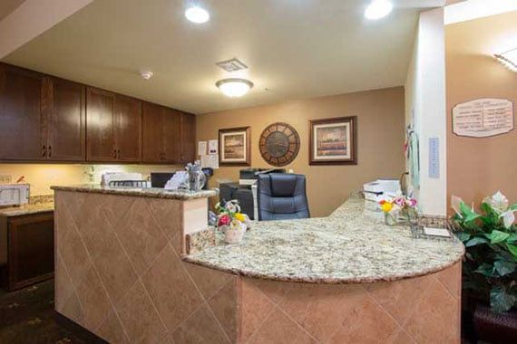 A welcoming reception area with a granite-topped desk and decorative elements.