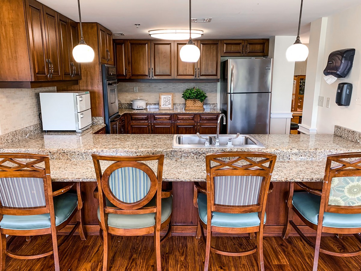 A modern kitchen featuring wooden cabinets, a granite countertop, and stainless steel appliances.