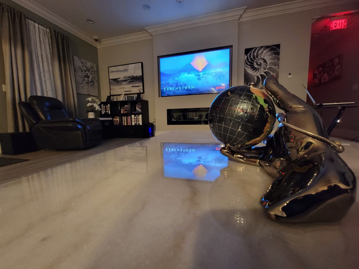 A modern living room featuring contemporary artwork and a large television.