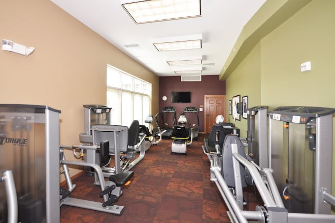 A modern gym with exercise equipment and natural lighting.