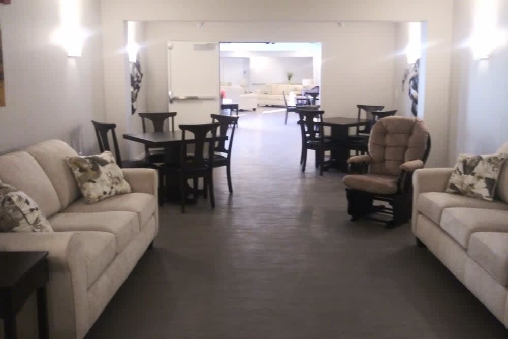 A cozy living room with sofas, chairs, and tables arranged for comfort.