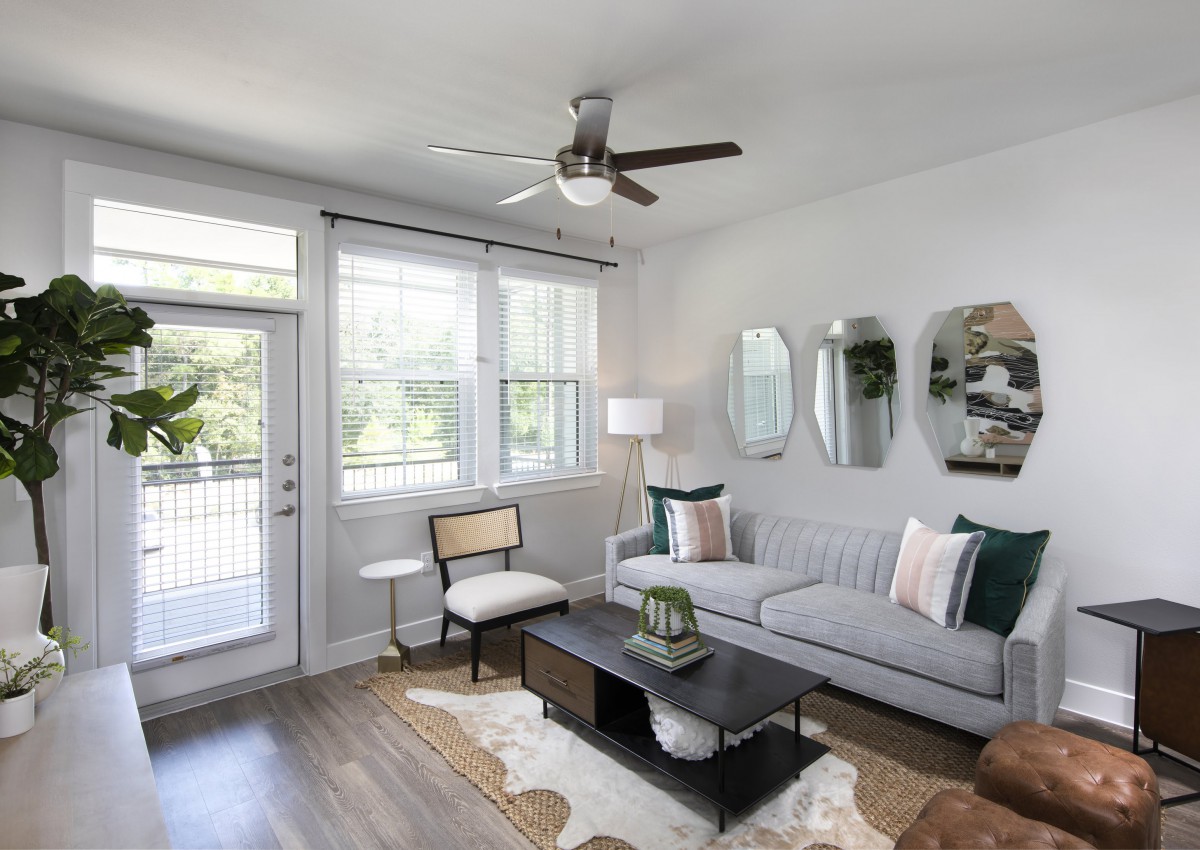 A modern, minimalist living room with a gray sofa and stylish decor.