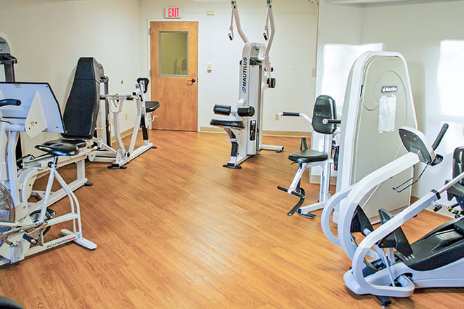 A gym room with various exercise machines and equipment.