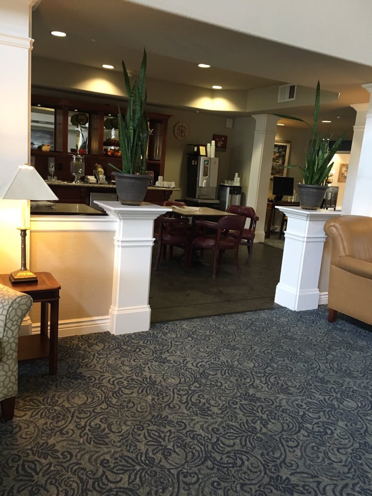 A cozy lobby area with seating and plants.