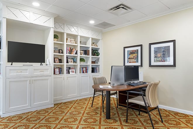 A well-organized office space with a desk, computer, and shelves filled with books.