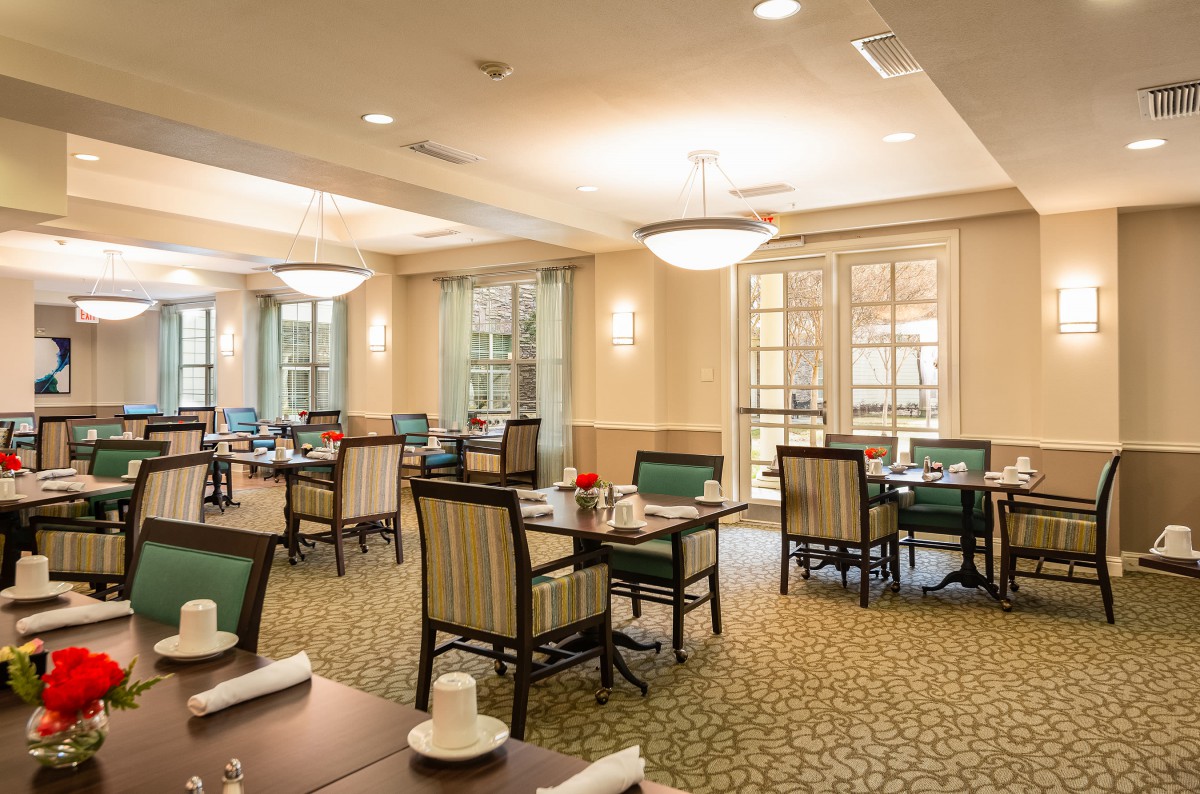 A well-lit dining room with neatly arranged tables and chairs, showcasing a cozy and inviting atmosphere.