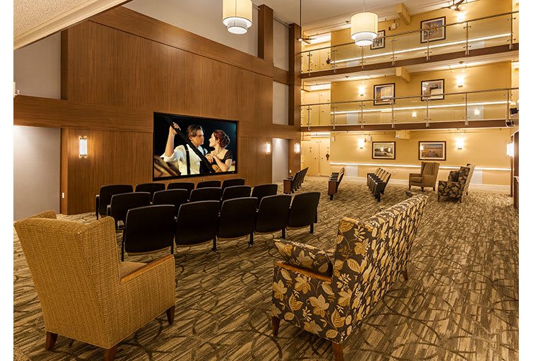 A cozy indoor theater with comfortable seating and a large screen, perfect for watching movies.