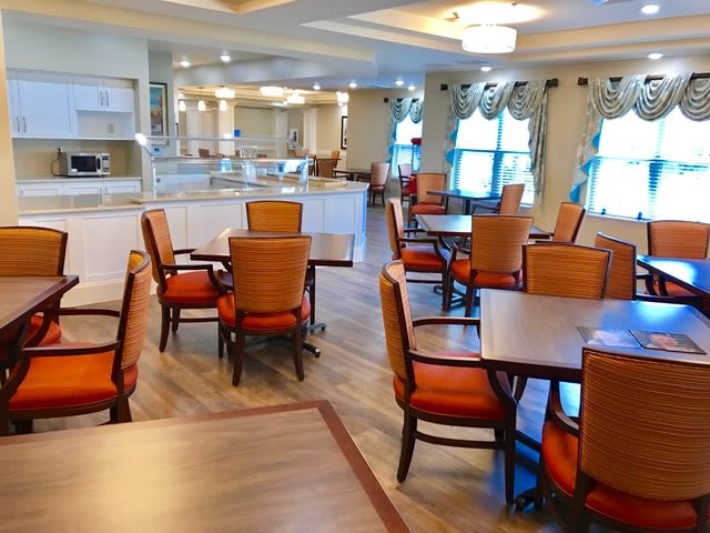 A well-lit dining area with neatly arranged tables and chairs, showcasing elegant interior design.