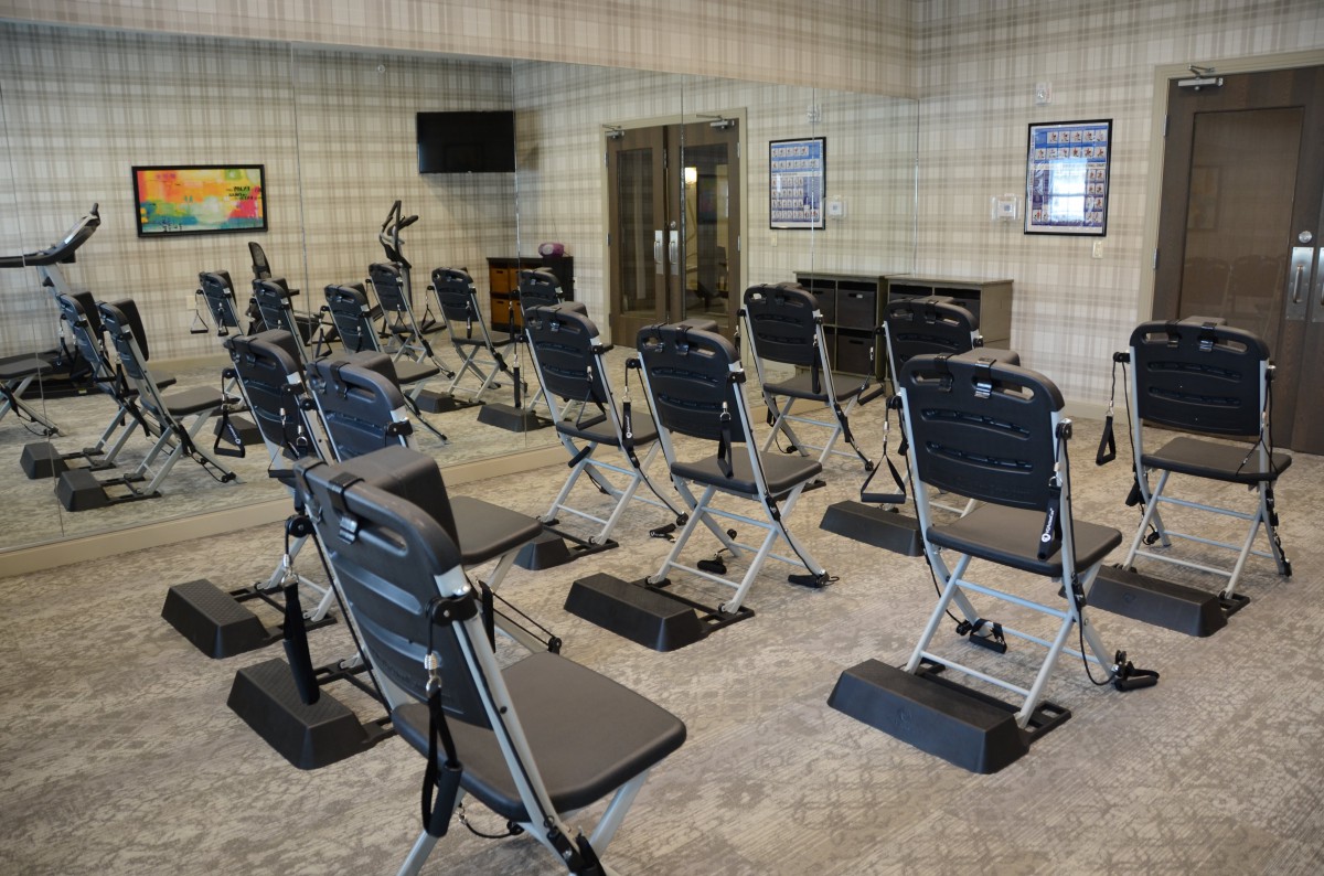 A gym equipped with multiple exercise machines arranged in rows.