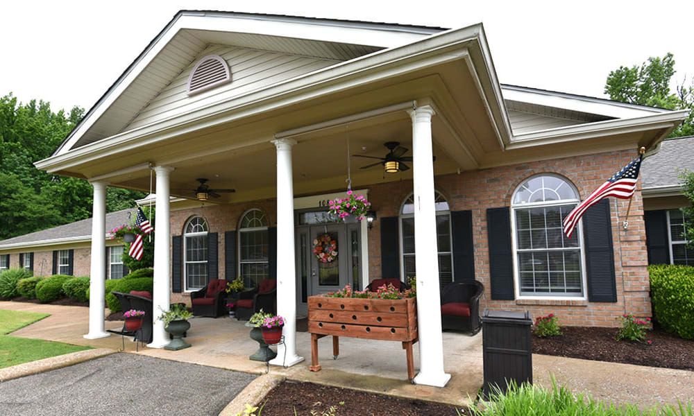 A welcoming building entrance with columns and outdoor seating.