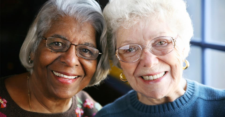 Two elderly women smiling together.