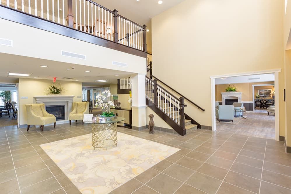A spacious and elegantly designed lobby featuring modern furniture, a central staircase, and an inviting atmosphere.